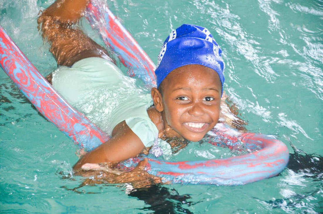 Confident young swimmer beaming during a Kiddies Aqua pool session